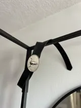 Cinto negro de cuero con hebilla plateada ovalada con diseño de cráneo de toro.