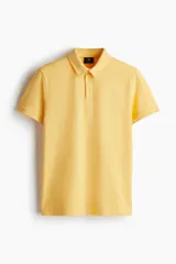 Remera polo de manga corta color amarillo, confeccionada en punto de algodón liviano. Tiene cuello clásico, tapeta con botones y corte ajustado.