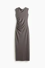 Vestido largo gris de punto elástico con leve brillo, corte entallado, escote drapeado, espalda escotada y pliegues laterales para crear un efecto drapeado. Sin mangas.