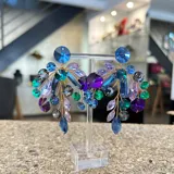 Aros colgantes hechos a mano con cristales Swarovski en tonos verde, lila y violeta.