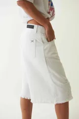Bermuda blanca de denim, tiro bajo, con cuatro bolsillos, pasacintos, cartera con cierre y botón metálico.