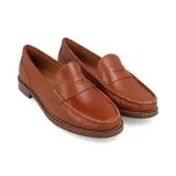 Mocasín de cuero color beige con suela marrón.