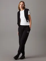 Pantalón de chándal negro de felpa con corte holgado, cintura elástica con cordón, puños de canalé, bolsillos laterales y monograma bordado de Calvin Klein en la cadera.
