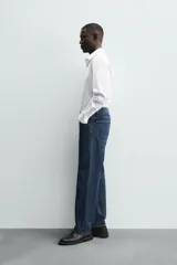 Camisa celeste de corte regular, con cuello italiano, mangas largas con puños abotonados y cierre frontal con botones.
