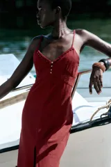 Vestido midi de lino color borgoña, con escote en pico, tirantes finos ajustables, botones frontales y abertura en el ruedo.