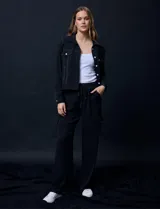 Pantalón cargo negro de crepe marca Ninety. Tiene pretina ancha elastizada en punto smock con lazo de ajuste y bolsillos cargo laterales.