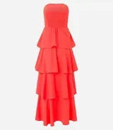 Vestido largo sin breteles, color naranja, hecho en crepé. Tiene lastex en la espalda y capas superpuestas en la pollera.