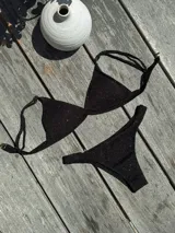 Conjunto de bikini turquesa con corpiño triangular de corte fijo, breteles regulables y almohadillas desmontables, y bombacha vedetina con frunce elástico en los costados.