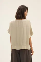 Blusa color beige de raso con ribete de lurex y mangas cortas.