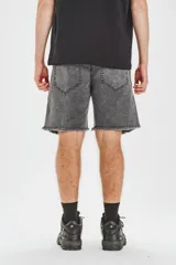 Bermuda gris con efecto lavado, de corte recto y largo a la rodilla. Presenta cintura con bragueta y botón metálico, bolsillos delanteros y traseros, y ruedo desflecado.