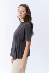 Remera gris oscuro de manga corta con cuello redondo y pinzas laterales que crean un efecto drapeado.