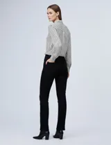 Camisa de manga larga, color blanco y negro, con cuello con solapa y abertura central con botones ocultos. Presenta un estampado geométrico repetitivo.