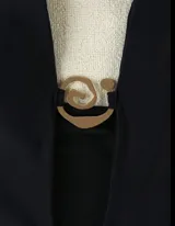 Malla enteriza negra con escote halter y abertura en el centro del pecho con aplique dorado.