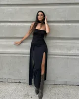 Vestido largo negro strapless con frunce en el busto, tajo lateral y lazo en la cintura. Incluye choker.