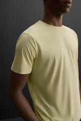 Camiseta deportiva color amarillo claro confeccionada en tejido técnico ligero y elástico. Cuenta con cuello redondo, manga corta, costuras termofijadas y estampaciones reflectantes en la espalda.