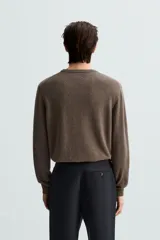 Jersey de hombre regular fit, color negro, tejido en hilatura de lana cashmere. Cuello redondo y manga larga con terminaciones en rib.