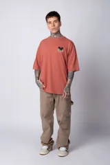 Remera blanca de algodón de corte oversize con mangas cortas y cuello redondo. Presenta un pequeño estampado en el frente con la figura de Mickey Mouse y caracteres orientales.