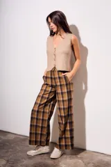 Pantalón de tiro medio, corte recto y pierna ancha, con estampado de cuadros escoceses en tonos marrón, beige y negro.