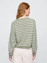 Sweater de punto color verde claro con rayas horizontales blancas, de corte holgado y cuello redondo.