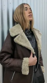 Chaqueta marrón gastado de cuero ovino con cuello y puños de piel sintética color crudo. Cierre frontal con cremallera y bolsillos laterales.