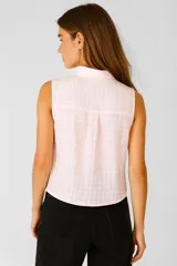 Blusa de algodón color crudo con estampado a cuadros, cuello camisero, cierre frontal con botones, bolsillo en el pecho y corte holgado.