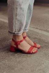 Sandalias rojas con textura símil cuero de cocodrilo, con tira delantera ancha, pulsera al tobillo con hebilla y taco cuadrado bajo.