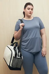 Remera deportiva color lila de manga corta con calce relajado y corte horizontal en la parte inferior.