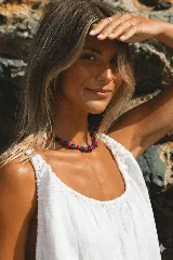 Collar corto de cuentas de cerámica rojas y azules con forma de estrella y esferas.