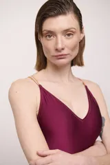 Malla entera color borgoña con breteles finos cruzados en la espalda, algunos color rosa y otros color dorado.