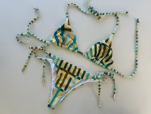 Conjunto de bikini con estampado geométrico en tonos beige, verde y celeste. El top es de triángulo con tirantes finos y la braguita es de corte clásico con tiras laterales ajustables.