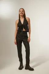 Pantalón negro de ecocuero, corte recto, tiro alto y cinturón con hebilla cuadrada.