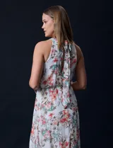 Vestido largo de gasa estampada con flores de colores, escote halter plisado, corte en la cintura elastizado, abertura en la espalda con lazo de ajuste y forro interno a tono.