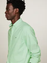 Camisa de hombre Tommy Hilfiger, modelo 1985 TH Flex, color verde claro. Corte regular, cuello abotonado, mangas largas con puños abotonados y logo bordado en el pecho. Confeccionada en algodón Oxford orgánico con Flex Technology.