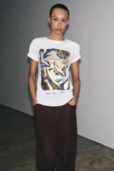 Camiseta blanca de algodón con cuello redondo, manga corta y estampado metalizado en el frente con formas abstractas y texto "AILGN92 SHAPES OF HARMONY".