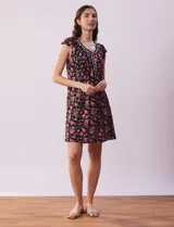 Camisón corto negro con estampado de lunares blancos, escote en V con puntilla blanca y botones.