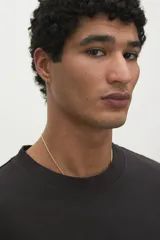 Remera negra de corte holgado con cuello redondo y mangas cortas. Estampado frontal con la inscripción "ORK XON NEW THE".
