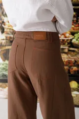 Pantalón de lino color crudo con finas rayas verticales negras, corte wide leg y tiro alto.