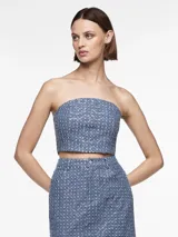 Top de denim azul mediano con detalles de lentejuelas y ajuste entallado.