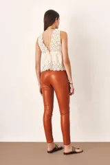 Pantalón legging de cuero color marrón con cierre en los bolsillos.