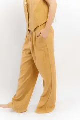 Pantalón de lino color mostaza, de corte recto, con cintura elastizada y costuras en contraste.