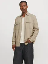 Sobrecamisa beige de manga larga con cuello clásico y fit cómodo. Confeccionada en tejido de sarga resistente de algodón y lino, con cierre con botones y bolsillos en el pecho con cierre de botón.