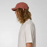 Gorra de gabardina color coral con logo de Caterpillar bordado en blanco en el frente.
