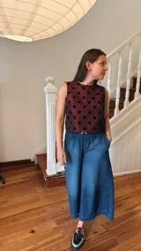 Remera corta de tafeta color verde militar con lunares de terciopelo negros, corte a la base y botón en la parte trasera.