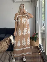 Vestido camisero largo negro con estampado de flores blancas y cinto incluido.