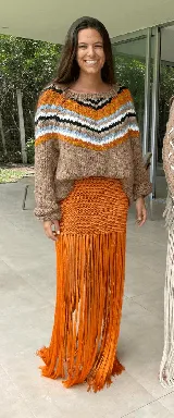 Falda larga tejida a mano en hilado de seda color naranja, con flecos largos.
