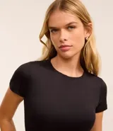 Body blanco de poliamida con cuello redondo y mangas cortas.