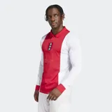 Camiseta de fútbol Adidas de manga larga, inspirada en el primer uniforme del Ajax de Ámsterdam, con diseño que combina un panel central rojo con mangas y costados blancos. Posee cuello de chomba rojo y puños acanalados rojos. En el pecho lleva el escudo conmemorativo del club con las tres cruces de Ámsterdam y el logo de Ziggo.