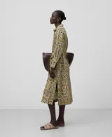 Vestido camisero midi de lino con estampado de piel de serpiente, cuello solapa, manga larga con volumen en el codo y puño abotonado, cierre frontal con botones y cinturón de lazo.