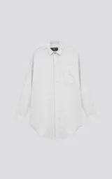Camisa manga larga blanca de calce oversize confeccionada en textil fresco y liviano, con bolsillo ojal en delantero y cartera escondida.