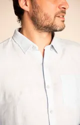 Camisa de manga larga color durazno, confeccionada en lino orgánico, con cuello italiano, cierre con botones y bolsillo en el pecho con logo bordado al tono.